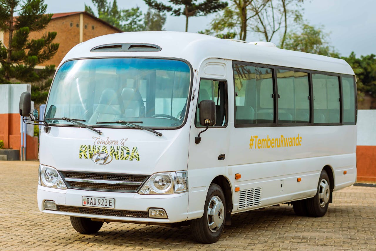 services-02 A white tourist bus with TemberuRwanda branding parked outdoors in Rwanda.