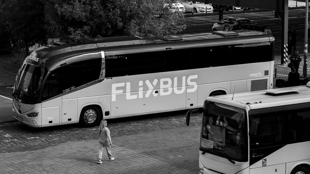 services-01 A monochrome photo of FlixBus parked at station with people nearby.
